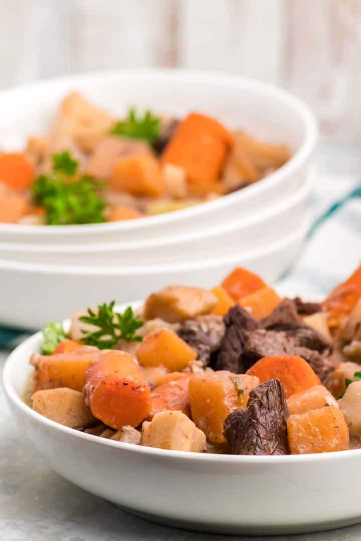 Beef and root vegetable stew in a white bowl.